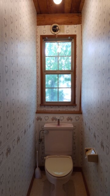 小窓から光が差し込む明るいトイレ空間